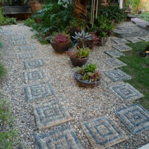 Gartenwege-aus-Kieselsteinen-viele-ziersteine-verwenden-einzelne-trittsteine-auflegen-pflanzentöpfe