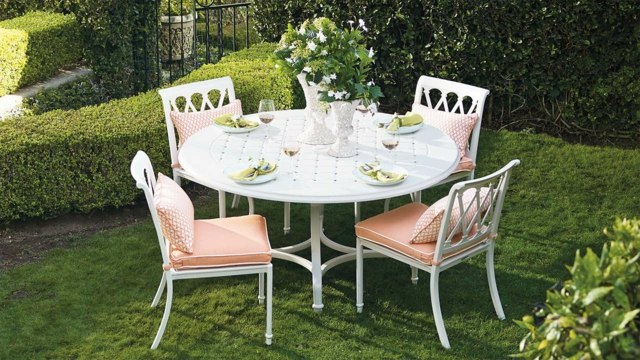 Sitzecke rosa Sitzkissen vier Stühle weißer runder Tisch