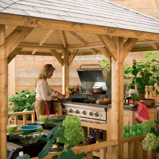 Küche im Garten frau kochen pavillon kochbereich gemütlich behaglich einladend 