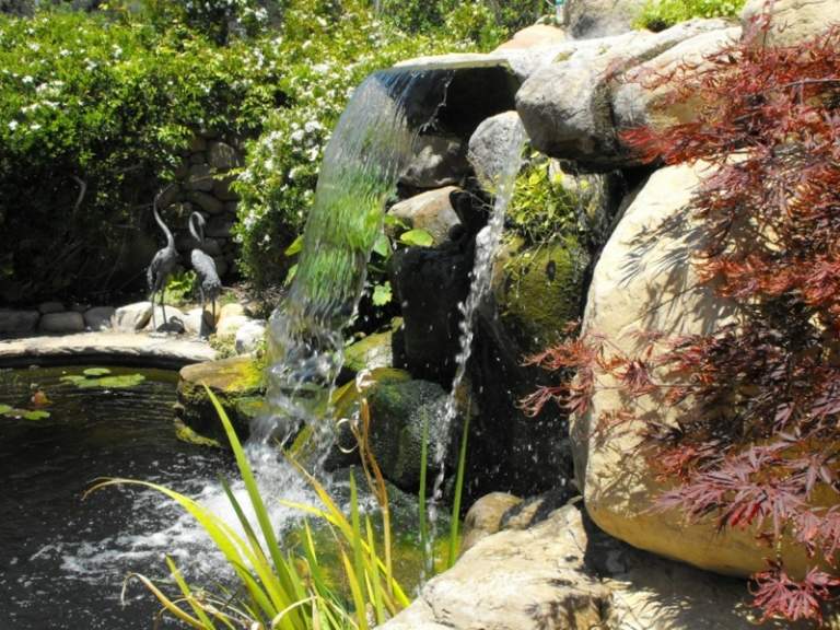 Wasserfall im Garten-Schwimmteich-Gartenfiguren-Stein-Voegel