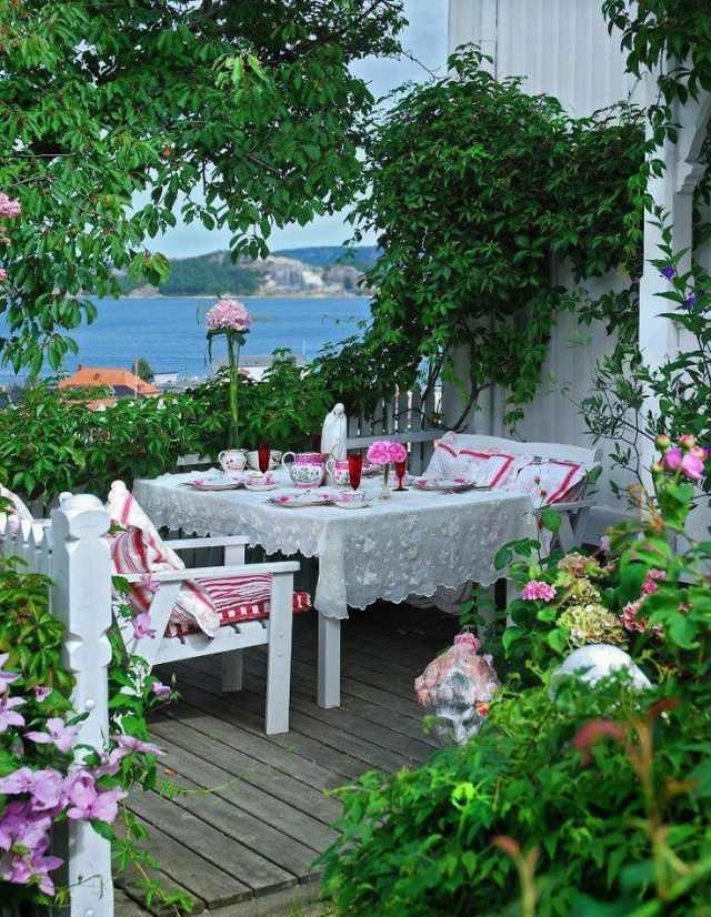 mediterrane Terrasse mit Meerblick Weiße stühle Tischdecke-florale muster
