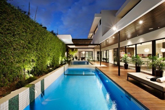 Modernes Haus mit Pool terrasse sichtschutz bambus hecke wasserspiel wasserfall
