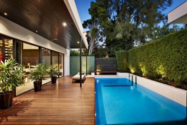 Modernes Haus mit Pool holzterrasse sichtschutz hecke pflanzkübel