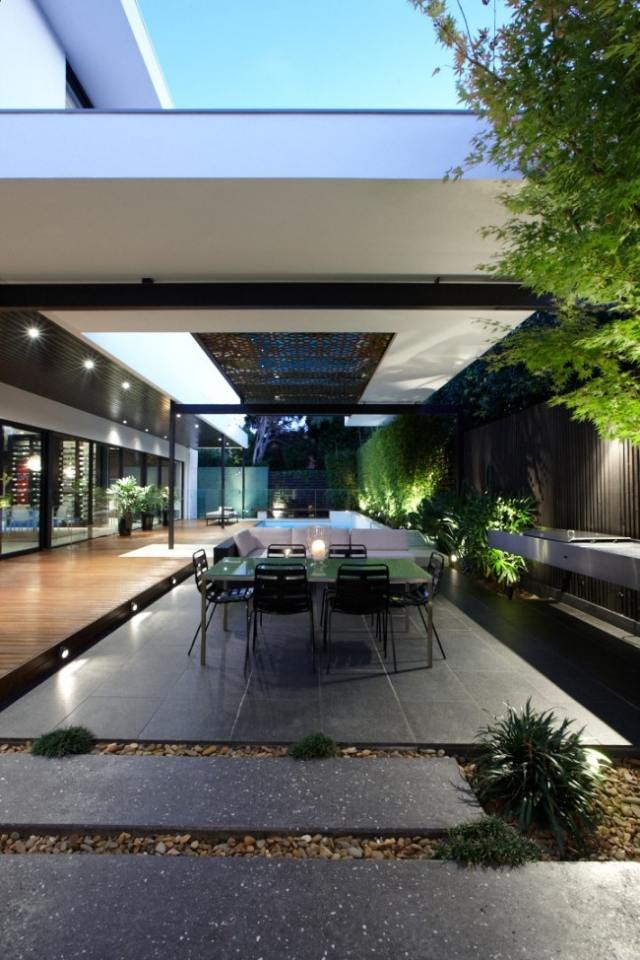 Modernes Haus mit Pool holzterrasse überdacht kies betonplatten