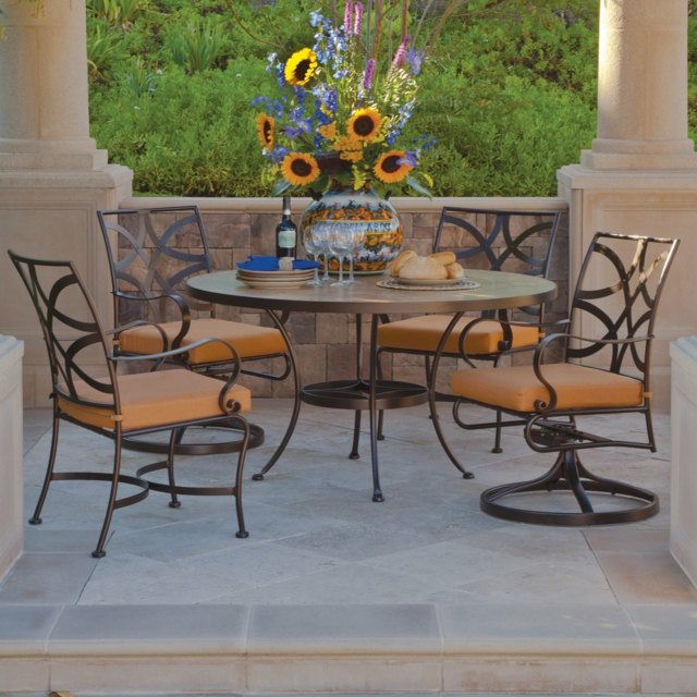 Metall Stühle Rundtisch Steinfliesen Sonnenblumen Vase Haus Terrasse