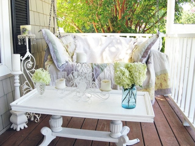 Terrasse weiße Holzmöbel Schaukelbett Deko Kissen hell lila