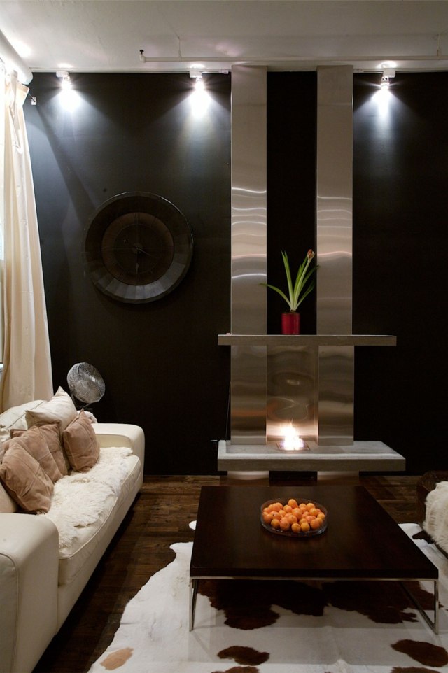Stil Holztisch dunkle Wände schwarze Farbe beige Sofa Kuhfell Teppich