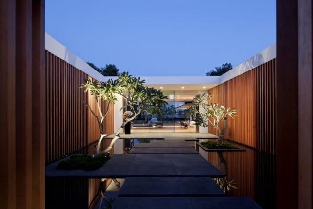 modernes einfamilienhaus spiegeleffekte innenhof bäume trittplatten