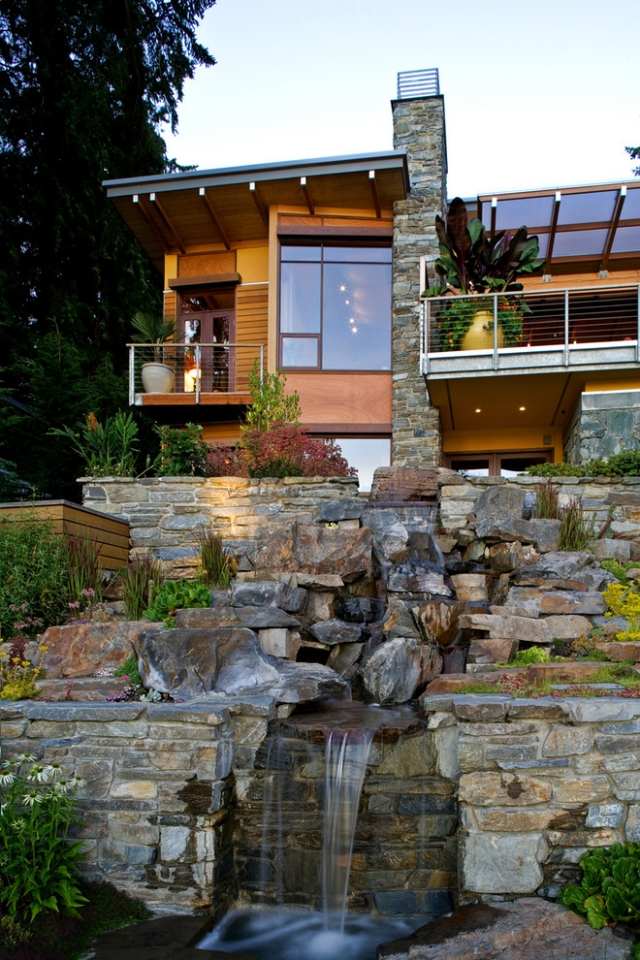 wohnhaushaus-naturstein schornstein-am fels gebaut natürliche optik wasserfälle