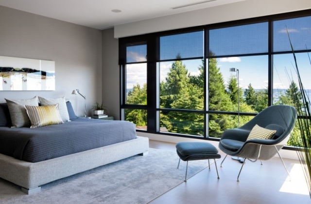modernes schlafzimmer fenster graues polsterbett teppich relaxsessel blau