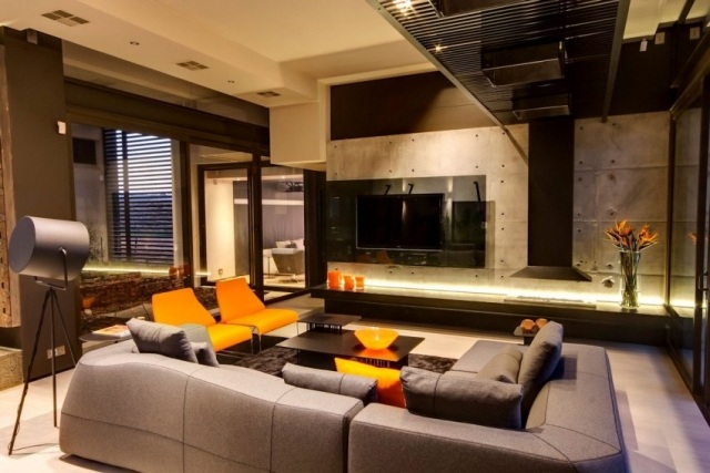 modernes-wohnzimmer-grau-orange-moebel-sichtbeton-weiss-holzboden