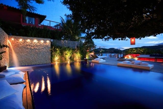 pool design wasserfall steinwand holz terrasse bodenkissen Insolito