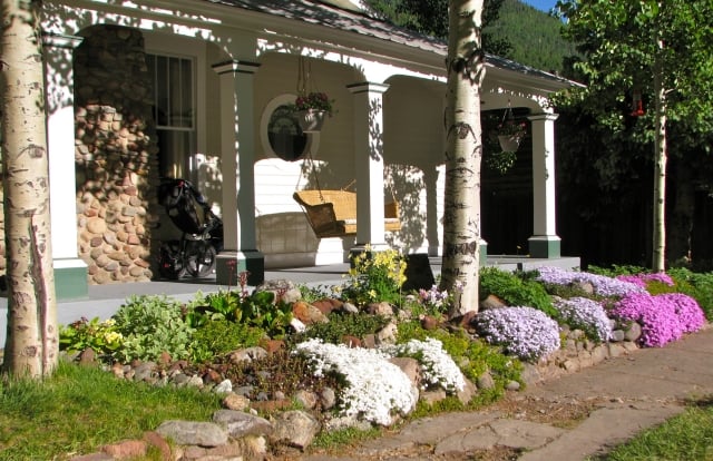 steingarten-anlegen-veranda-schaukel-polsterstauden-farbe
