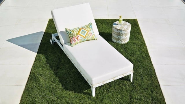 weißer Liegestuhl Rasenfläche Beistelltisch Dekokissen Rollen