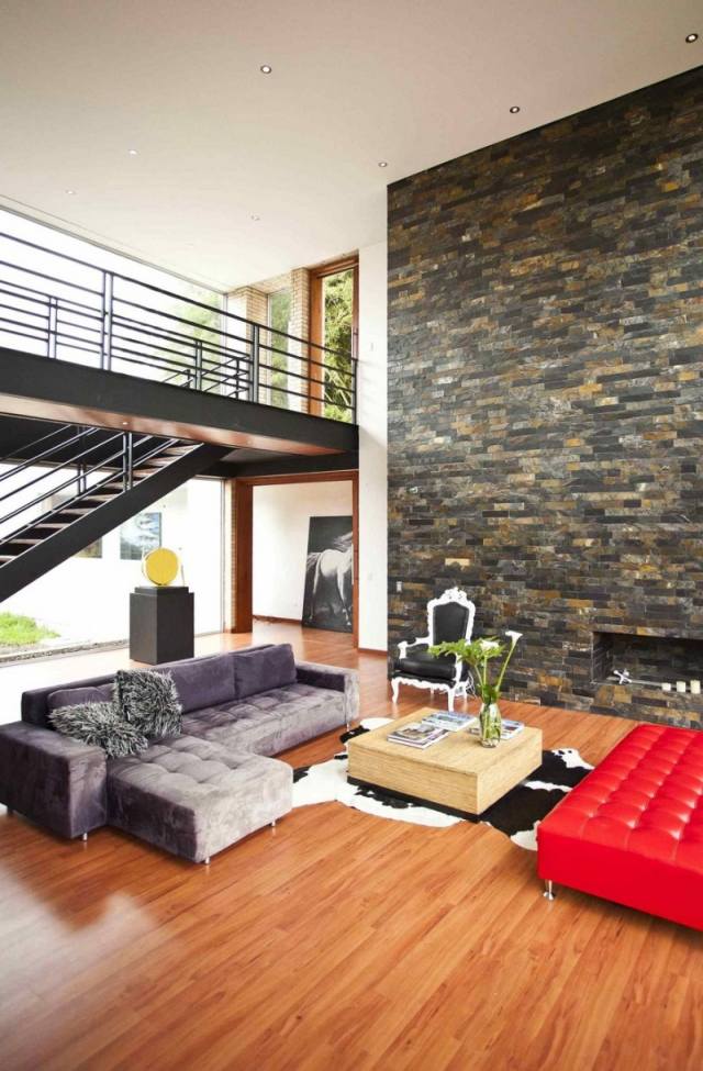 wohnzimmer wandgestaltung-naturstein holzbodenbelag laminat polstermöbel beistelltisch teppich kuhfell-optik