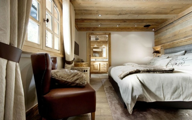 Ledersessel Doppelbett weiße Wände Holzboden Belag