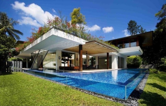 Fiberglas-pool-bauen-transparente-Seitenwände-Umrandung-Flusssteine-moderne-Villa