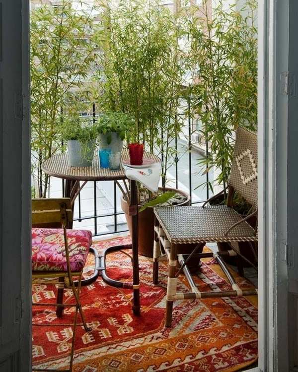 Flechtmöbel-für-Balkon-bunt-boho-chic-dekoideen-rustikaler-teppich-vintage-stühle-bambusgestell