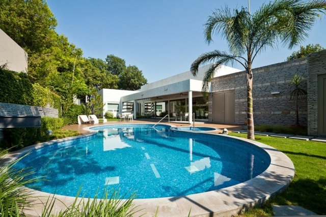 moderne Architektur runder Pool Palmen Rasenfläche
