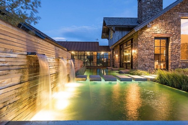 Haus-mit-Stein-Front-Sichtschutz-Mauer-Wasserfall-Pool-Beleuchtung-Trittsteine