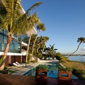 Karibien Ferienvilla hohe Palmen Pool Holzterrasse schöner Blick Glasfronten