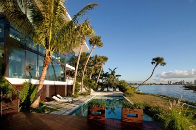 Ferienvilla hohe Palmen Pool Holzterrasse schöner Blick Glasfronten