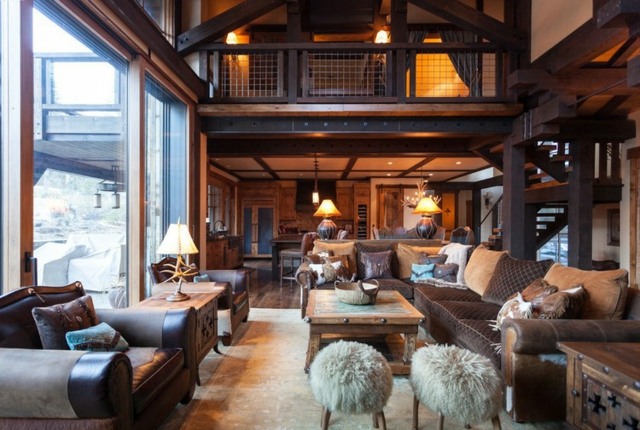 Wohnzimmer Hüttenstil einrichten Möbel Leder Pelz gepolstert Holztische zwei Etagen hohe Decke