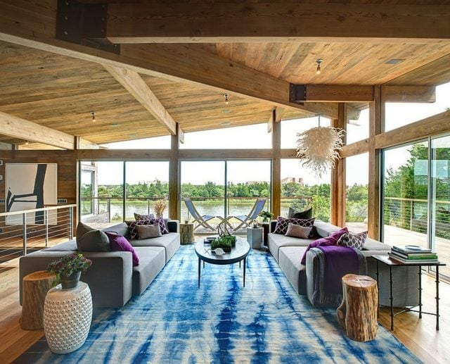 Teppich rustikale Beistelltische Baumstamm Holzdecke blau Farbakzente