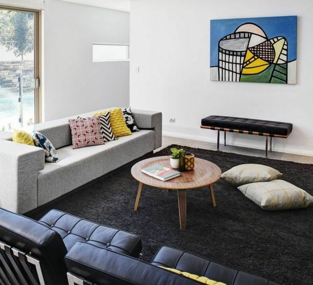 skandinavischer Wohnstil Sofa bunte Deko Kissen Wandmalerei