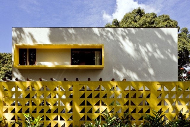 haus aus beton bauhaus-architektur weiße fassade zaun gelb öffnungen