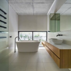 freistehende Badewanne Badezimmer sparsam einrichten Waschbecken Unterschrank langer Spiegel