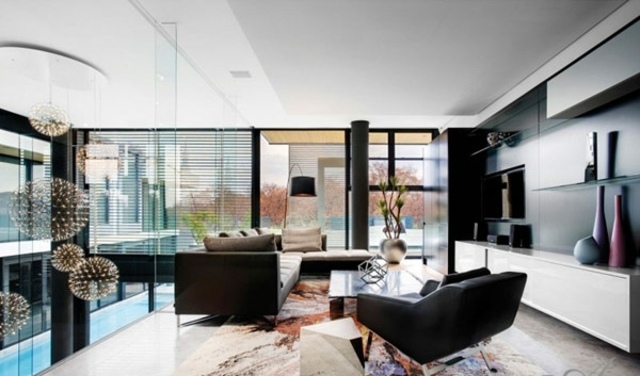 einrichten Wohnwand weiße Farbe Regalsystem schwarzes Sofa Teppich