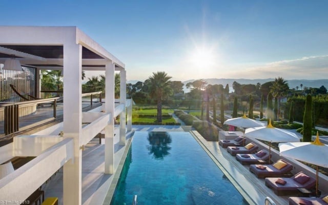 luxus-ferienvilla infinity pool sonnenliegen palmen