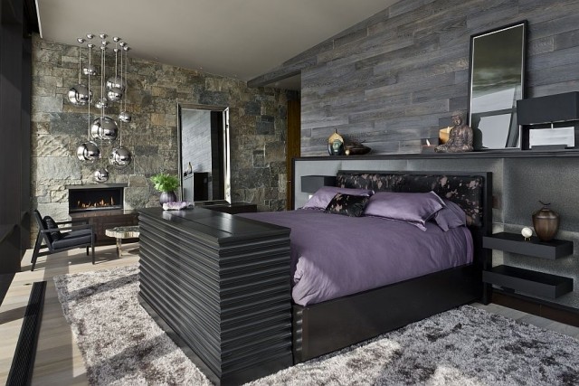 luxus-schlafzimmer-schwart-grau-natursteinwand-kamin-pendelleuchten