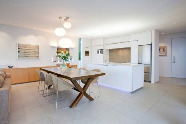moderne wohnküche mit kochinsel-weiße oberschränke grifflos-rustikaler Esstisch