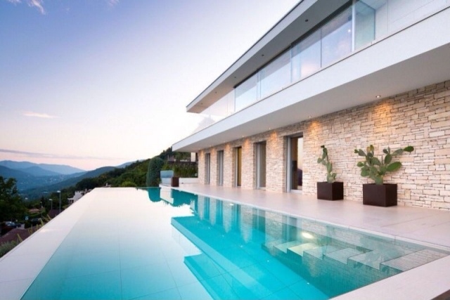 modernes-Haus-mit-Steinfassade-Blumenkübel-infinity-pool