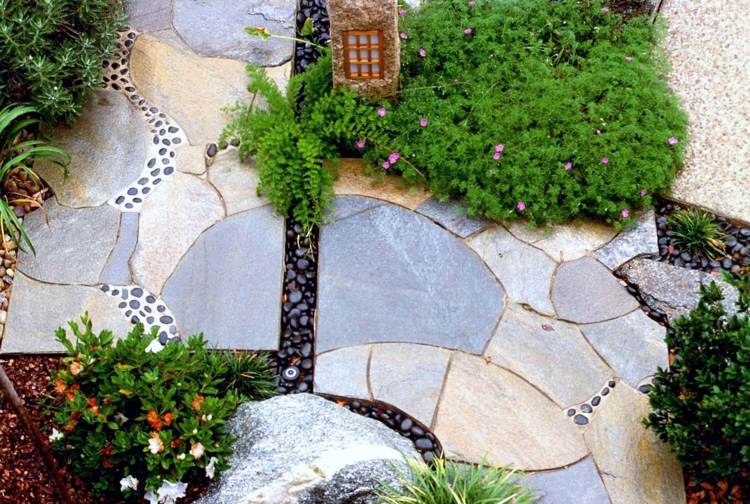 Bodenbelag im Garten gehweg-natursteinplatten-luecken-mosaik-schwarze-ziersteine