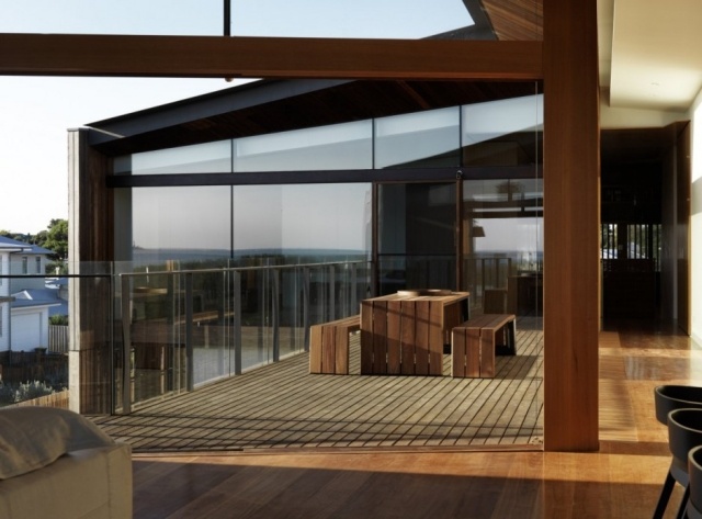 Haus-an-der-Küste-Aussichtssterrasse-Holzsitzbank-Fensterfront-spiegel