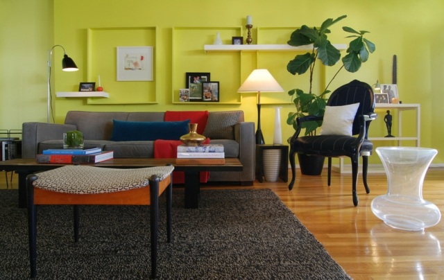 Wohnzimmer gestalten Farben Wand Akzent graues Sofa orange Polsterhocker blau Dekokissen