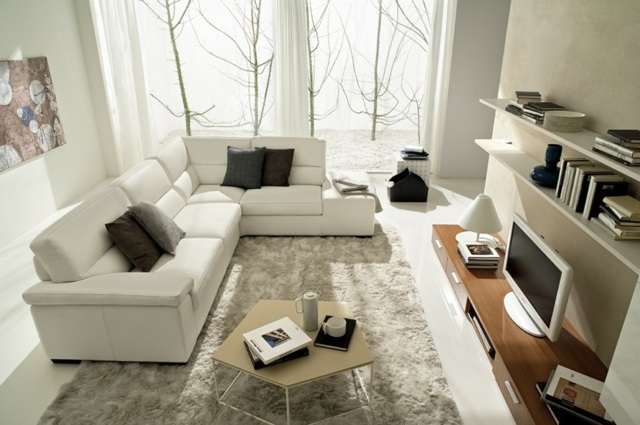 Asymmetrischer-Tisch-weißes-Sofa-Holzelementen-Wandregal