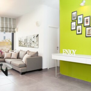 Wohnzimmer Limettengrün Akzent Wand streichen neutrale Farbe Ecksofa Deko Kissen