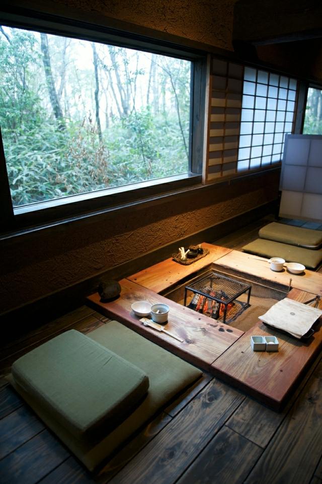 gemütliche Sitzecke niedriger Holztisch Feuerstelle japanischen Stil Sitzkissen Boden