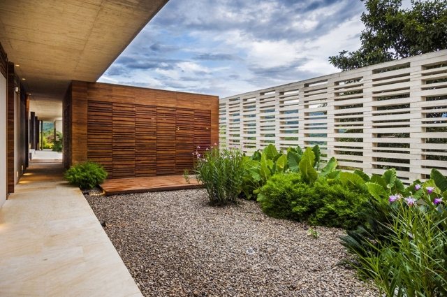 landschaftsbau-modern-betonmauer-ausschnitte-holzwand-kies-bodenbelag