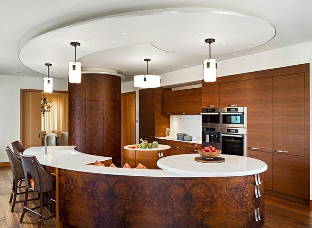 moderne-große-Küche-halbrunde-Kochinsel-Hängedecke-Pendelleuchten-warme-Holz-Farbe