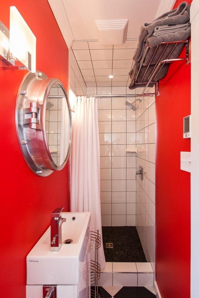 platzsparende-gestaltung-kleine-badewanne-rote-wände-fliesen-duschbereich