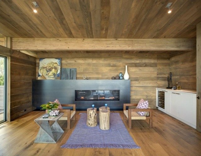 Optik modernes Wohnzimmer einrichten Baumstamm Tisch lila Teppich