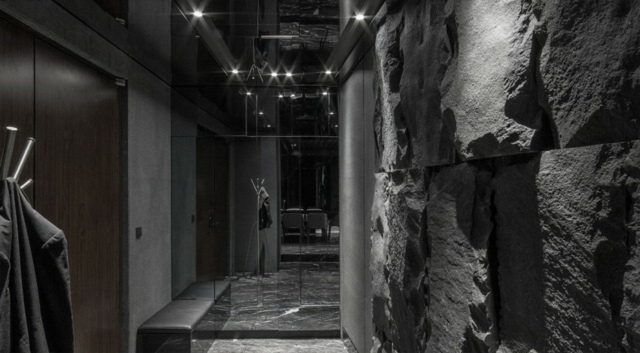 Eingangstür-offener-Flur-Granit-Stein-ungerade-Wände-Wohnzimmerbereich