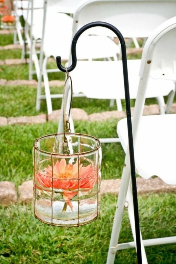 Stühle-zum-Altar-aufgehängter-Glasbehälter-mit-Rosenblüten-im-Wasser