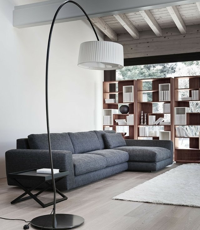  graues Sofa Holz Wandregal übergroße weiße Stehlampe