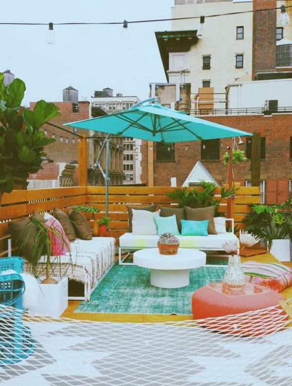 begrünte-terrasse-sonnenschirm-palettenmöbel-sichtschutz-ideen